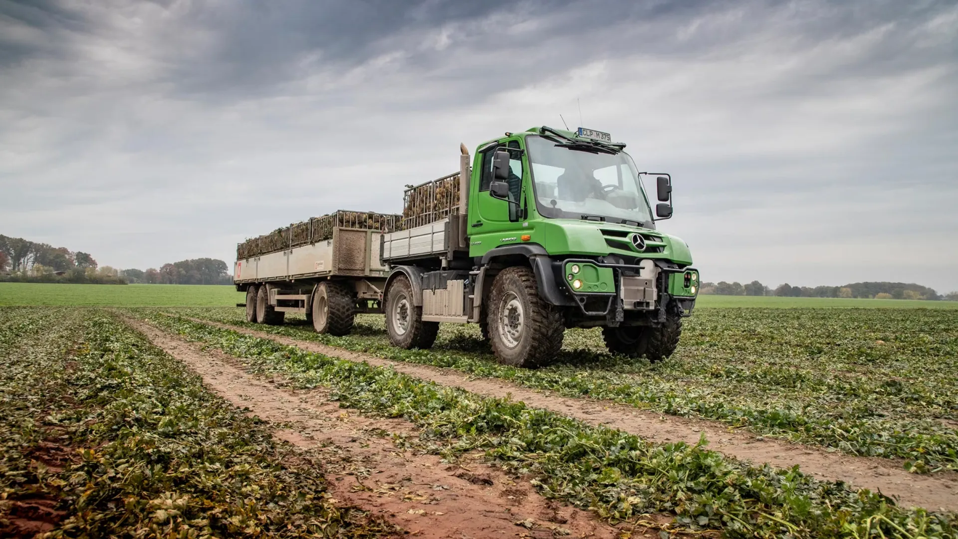 green-mercedes-benz-unimog-working-in-farm