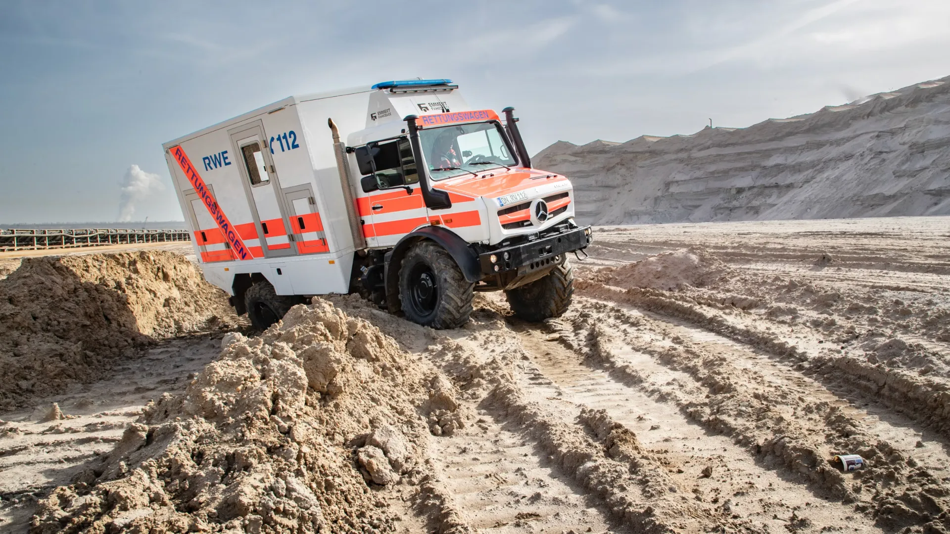 white-mercedes-benz-unimog-in-sand
