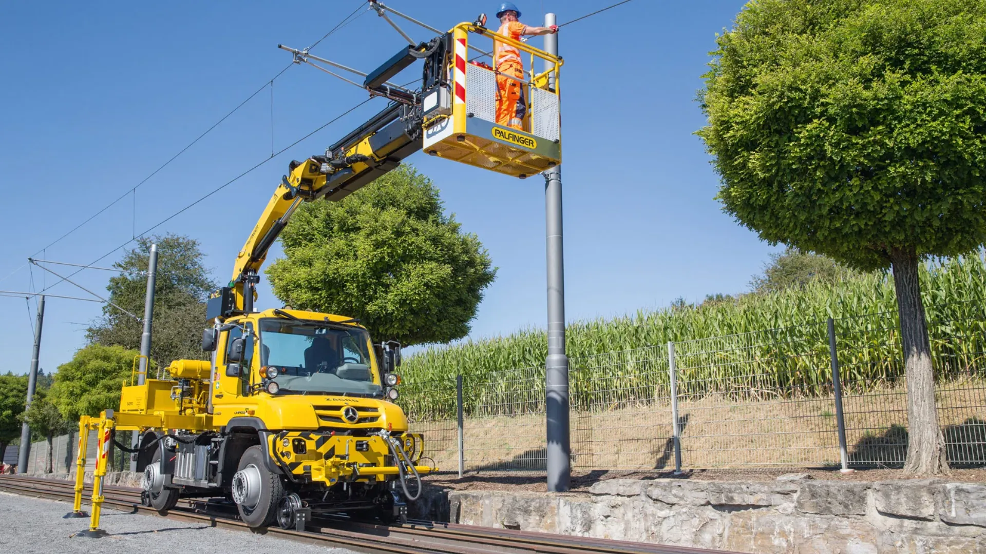 yellow-mercedes-benz-unimog-on-railway-line